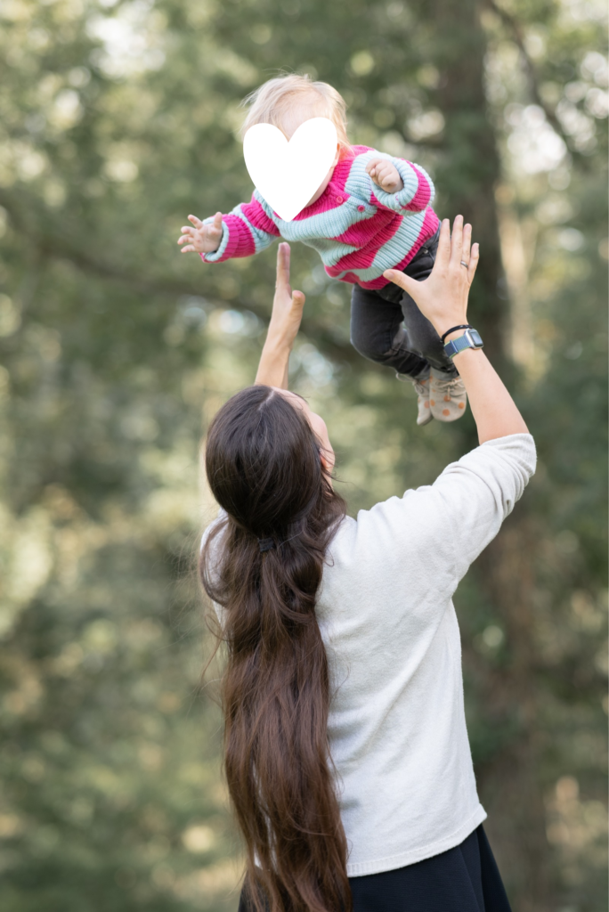 Foto einer Mama, die ihr Kleinkind in die Luft wirft