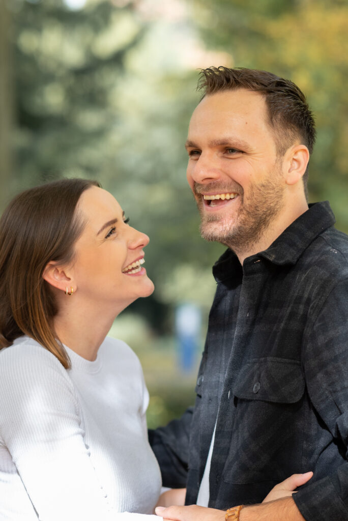 Foto eines Paares, dass sich gegenüber steht. Beide lachen.