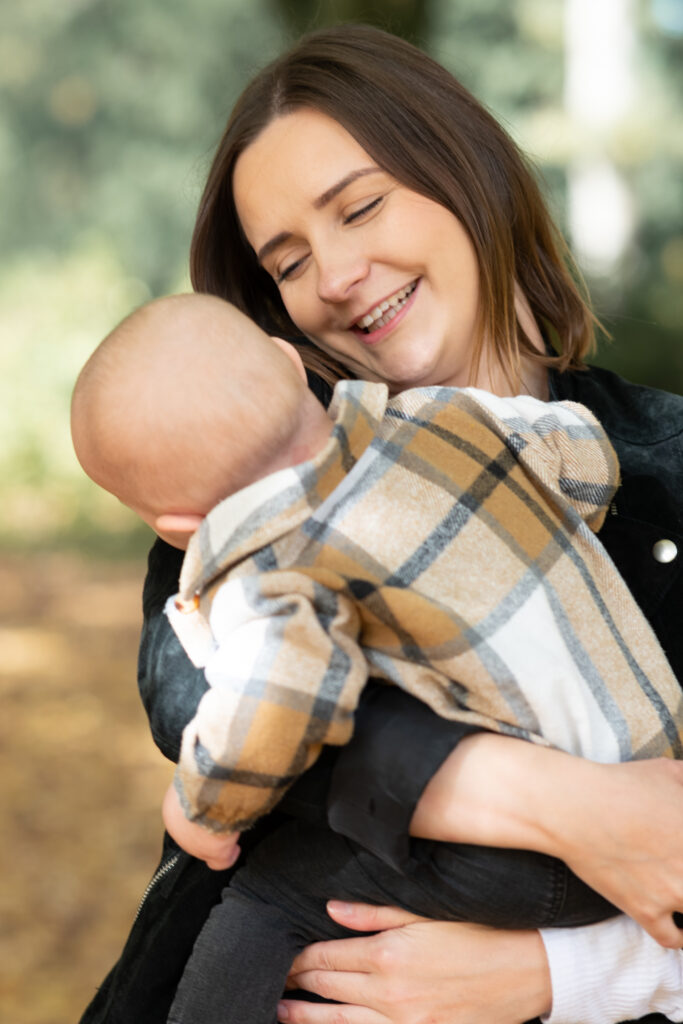 Bild einer Mama mit Kleinkind auf dem Arm. Die Mama lächelt das Kleinkind an. Buche dein Fotoshooting in Mönchengladbach